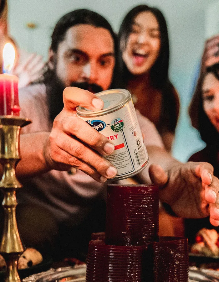 A group of people stacking canned cranberry sauce.